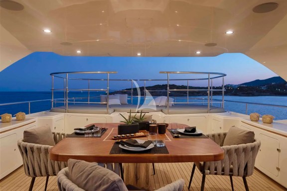 The spacious unobstructed sundeck has a jacuzzi pool with a large sunbathing area all around it, a bar, a dining table and sunbeds