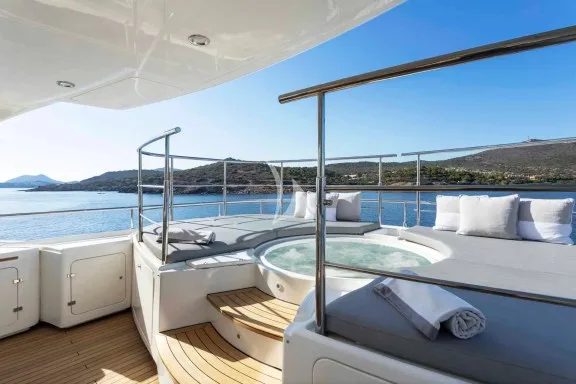The spacious unobstructed sundeck has a jacuzzi pool with a large sunbathing area all around it, a bar, a dining table and sunbeds