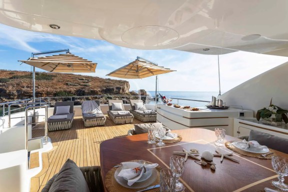 The spacious unobstructed sundeck has a jacuzzi pool with a large sunbathing area all around it, a bar, a dining table and sunbeds