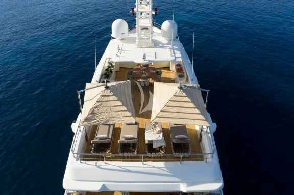 The spacious unobstructed sundeck has a jacuzzi pool with a large sunbathing area all around it, a bar, a dining table and sunbeds