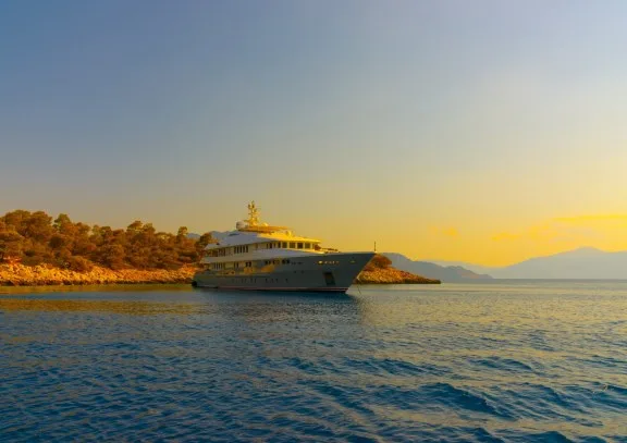 Superyacht anchored off a pine-covered islet in the Saronic Gulf, Greece